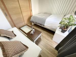 małą sypialnię z łóżkiem i stołem z tacą w obiekcie M Ikebukuro Apartment0107 w Tokio
