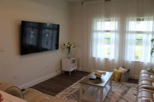 sala de estar con sofá y TV en la pared en Lake Marlin Villa en Port Charlotte