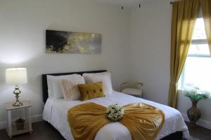 Lake Marlin Villa في بورت شارلوت: غرفة نوم عليها سرير وبطانية ذهبية