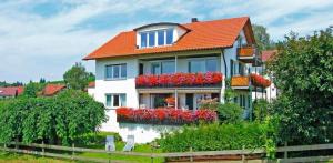 a house with flowers in the window boxes at Haus Kees- Apaartement in Kressbronn am Bodensee in Kressbronn am Bodensee