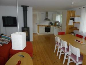 cocina y sala de estar con mesa y sillas en Großes Ferienhaus auf Gotland 700 Meter zum Meer en Ljugarn