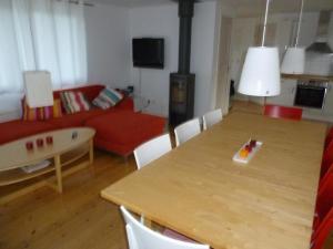 una sala de estar con una mesa con una tabla de surf. en Großes Ferienhaus auf Gotland 700 Meter zum Meer en Ljugarn