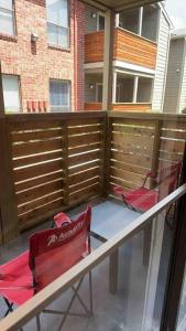 Duas cadeiras vermelhas sentadas numa varanda com uma cerca em Luxurious Apt With King Bed-MedCenter-Free Parking em Houston