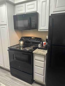 uma cozinha com um fogão preto e um micro-ondas em Luxurious Apt With King Bed-MedCenter-Free Parking em Houston