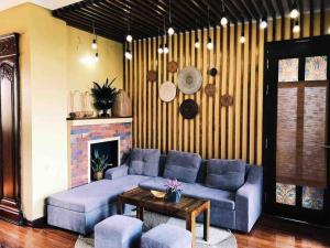 sala de estar con sofá azul y chimenea en POMELO - Sun's Homestay - Lake View, en Hanói