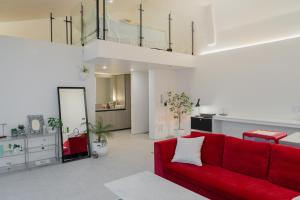 a living room with a red couch and a kitchen at Ohyeongjae Private Pool Villa in Jeju