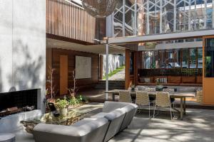 een woonkamer met een bank en een tafel bij Surf Poet, Unique Rainforest Retreat Luxury Home in Noosa Heads