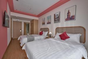 a hotel room with two beds with red pillows at Oceanhomes in Bien Ho