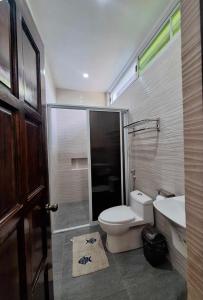 a bathroom with a toilet and a sink at Fins Pacific Coray Bay by Hiverooms in Samboan