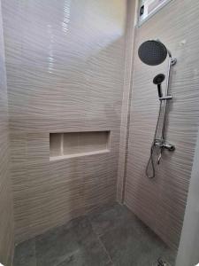 a shower with a shower head in a bathroom at Fins Pacific Coray Bay by Hiverooms in Samboan