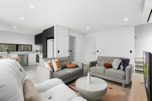 a living room with two couches and a table at Modern Sunny 3Bed 2.5Bath in Christchurch