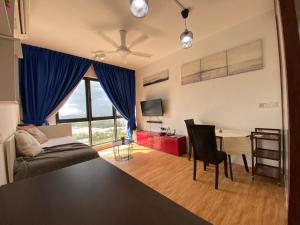a living room with a couch and a table with a desk at Modern 7-Pax Retreat Steps from IOI City Mall in Serdang