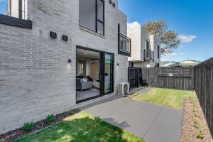 a house with glass doors and a backyard at Modern Sunny 3Bed 2.5Bath in Christchurch