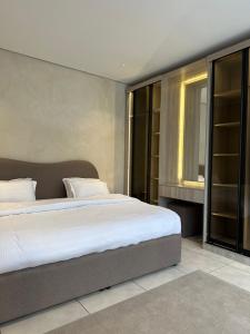 Un dormitorio con una cama grande y una ventana en شاليهات جزلا, en Al Hofuf