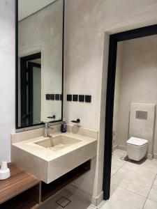 La salle de bains est pourvue d'un lavabo et de toilettes. dans l'établissement شاليهات جزلا, à Al Hofuf
