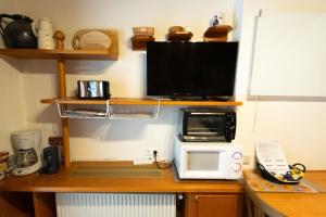 a desk with a microwave and a computer on it at Charmante Ferienwohnung in Gemeinde Flattach mit Beheiztem gemeinsamem Pool in Flattach