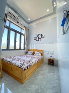 a bedroom with a wooden bed and a window at PHONG'S HOUSE in Cu Lao Thu