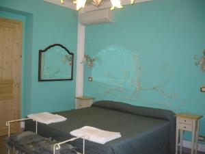 Dormitorio azul con cama y espejo en Gästezimmer für 0 Personen 3 Kinder ca 30 qm in Pucciarelli, Trasimenischer See, en Pucciarelli