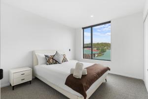 a white bedroom with a bed and a window at Stylish Cosy 2 Bed in Christchurch