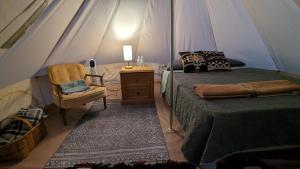 a bedroom with a tent with a bed and a chair at La Window Glamping in La Ventana