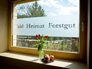 a window with a vase of flowers and a sign on it at Modernes Holzhaus mit Sauna, Whirlpool und Entspannungsraum in Regen