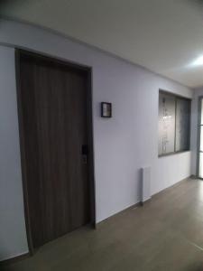 an empty room with a door and a window at Suite con hamaca y baño privado. in Manizales
