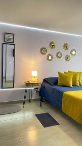 a bedroom with a bed and a table and mirrors at Suite con hamaca y baño privado. in Manizales