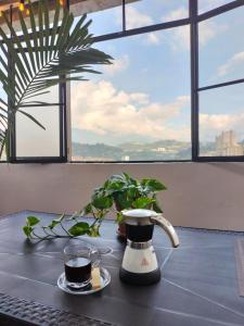 una mesa con dos tazas de café en una mesa en Suite con hamaca y baño privado. en Manizales