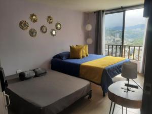 a bedroom with two beds and a balcony with a view at Suite con hamaca y baño privado. in Manizales