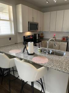 a kitchen with a sink and a counter with bar stools at Luxury 2bedroom condo in Fairburn