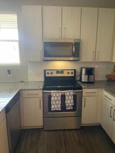 a kitchen with a stove and a microwave at Luxury 2bedroom condo in Fairburn