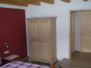 a bedroom with a wooden cabinet next to a bed at Direkt am Waldrand gelegene Ferienwohnung, ideal für Wanderer im Sommer und Wintersportler in der kalten Jahreszeit in Oberstaufen