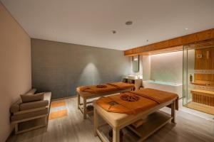 a room with two beds and a chair in it at Awaken Da Nang Hotel in Danang