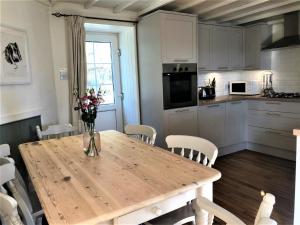 a kitchen with a wooden table with a vase of flowers on it at 3 Bed in Conwy TYPLL in Llangelynin
