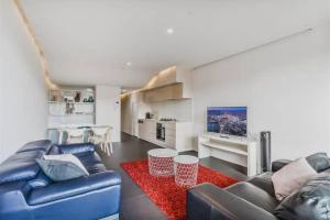 a living room with a blue couch and a red rug at Apartment nestled between Lake Burley Griffin, city and ANU in Canberra