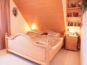 - une chambre avec un lit en bois et une étagère à livres dans l'établissement Große Ferienwohnung in Rauenstein mit Garten, Terrasse und Grill und Panoramablick, à Rauenstein