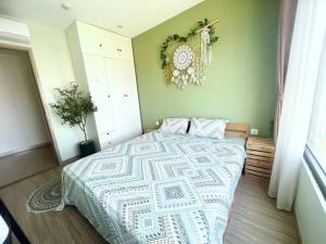 1 dormitorio con 1 cama y una corona en la pared en Oceanhomes S202 with 2 bebs, en Gia Lâm Pho
