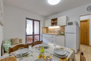 a kitchen with a table with plates and wine glasses at Nettes Appartement in Rovinj mit Garten, Terrasse und Grill in Rovinj