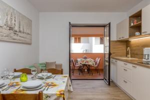 a kitchen with a table and a dining room at Nettes Appartement in Rovinj mit Garten, Terrasse und Grill in Rovinj