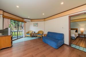 a living room with a blue couch and a bedroom at Botany Beach Resort in Na Jomtien