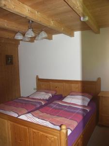 2 Betten in einem Schlafzimmer mit Holzdecken in der Unterkunft Ferienwohnung im Bayerischen Wald für 5 Personen in Kollnburg