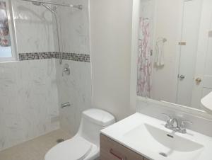 a bathroom with a toilet and a sink and a shower at Small Cozy Private Room For 1 or 2 Travellers in a Great Location (King George Boulevard, Surrey) in Surrey