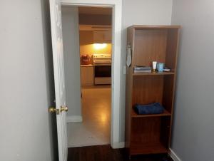 a hallway with a kitchen and a door to a room at Small Cozy Private Room For 1 or 2 Travellers in a Great Location (King George Boulevard, Surrey) in Surrey