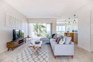 a living room with a couch and a tv at The Platinum Luxury Villa ~ Walk to Beach, Village in Sunshine Beach