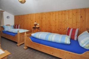 two beds in a room with wooden walls at Komfortable Ferienwohnung im zweiten Obergeschoss mit herrlichem Bergblick in Reit im Winkl