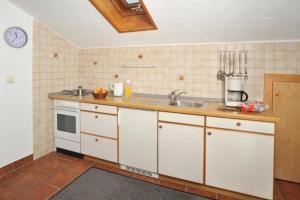 una cocina con armarios blancos y fregadero en Komfortable Ferienwohnung im zweiten Obergeschoss mit herrlichem Bergblick en Reit im Winkl