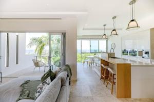 a living room and kitchen with a couch and a counter at The Platinum Luxury Villa ~ Walk to Beach, Village in Sunshine Beach