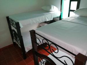 La Tortuga的住宿－FINCA LA ALDEA Cabañas campestres，两张睡床彼此相邻,位于一个房间里