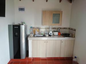 a kitchen with a sink and a refrigerator at FINCA LA ALDEA Cabañas campestres in La Tortuga