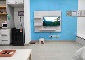 a kitchen with a tv on a blue wall at Cozy Stay at Shaftsburry, Urban Convenience #SH1 in Cyberjaya